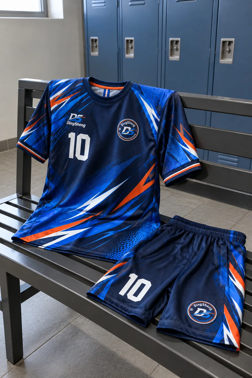 DingSheng branded blue and orange jersey and shorts arranged on a changing-room bench